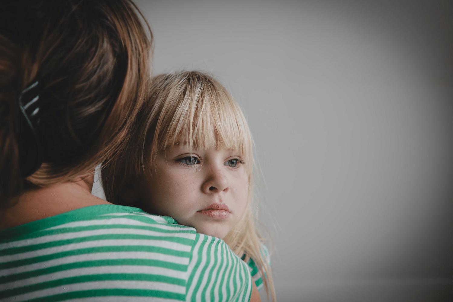 sad crying little girl hugging mother